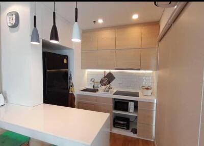 Modern kitchen with black refrigerator and white countertops