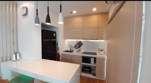 Modern kitchen with black refrigerator and white countertops