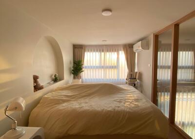 Cozy bedroom with a large bed, bedside table, and natural light