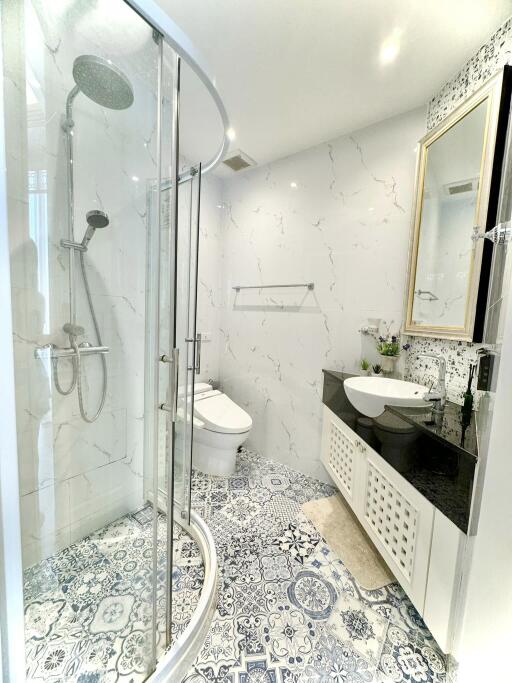 Modern bathroom with glass shower and marble walls