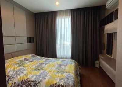 Modern bedroom with floral bedspread and large window