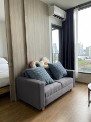 Cozy living room with a sofa, pillows, and a view over the city