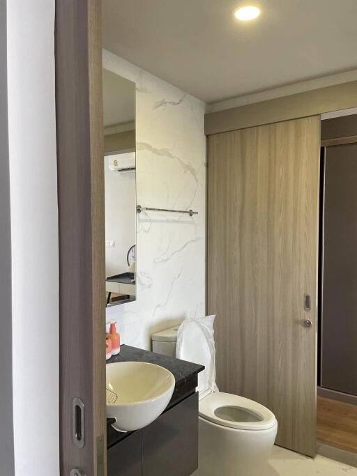 Modern bathroom with sink, toilet, and sliding door