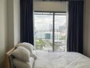 Modern bedroom with large window and city view