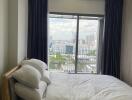 Bright bedroom with large window and city view