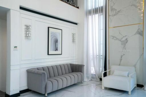 Modern living room with grey sofa and white armchair