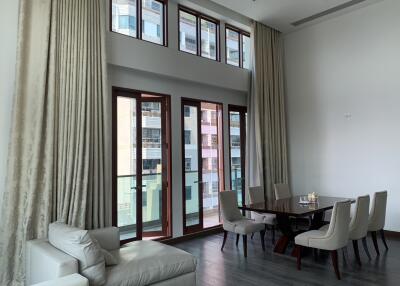 Spacious living room with high ceilings and large windows