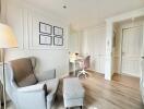 Bright bedroom with armchair, ottoman, and work desk