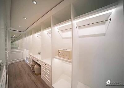 Spacious walk-in closet with built-in shelves and drawers