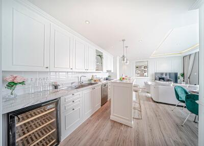 Modern open-plan kitchen and living area with white cabinets and wooden flooring