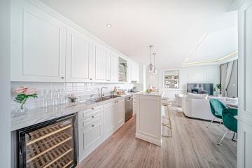 Modern open-plan kitchen and living area with white cabinets and wooden flooring