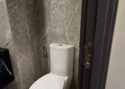 Modern bathroom with a toilet and stone wall tiles