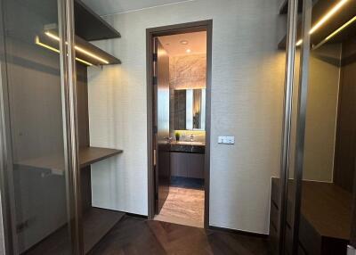 Closet with shelves and a view into a bathroom