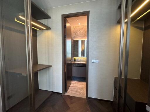 Closet with shelves and a view into a bathroom