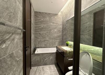 Modern gray tile bathroom with bathtub and sink