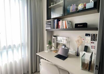 A modern home office with a desk, chair, and shelves