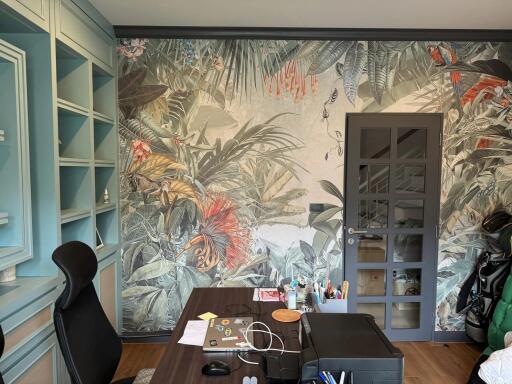 Home office with tropical wallpaper and desk