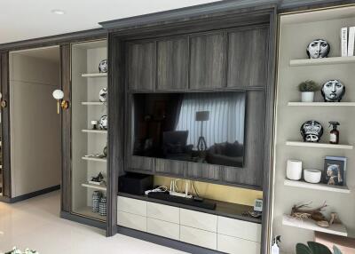 Modern living room with built-in TV and decorative shelves