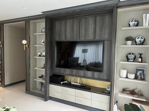 Modern living room with built-in TV and decorative shelves