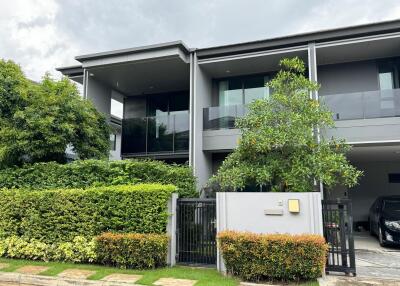 Modern two-story building exterior with greenery