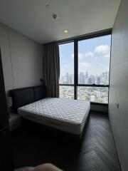 Bedroom with large window and city view