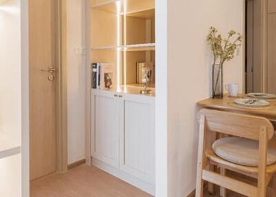 Cozy dining area with wooden table and chairs, adjacent to built-in shelving unit with decorative elements