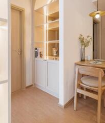 Cozy dining area with wooden table and chairs, adjacent to built-in shelving unit with decorative elements