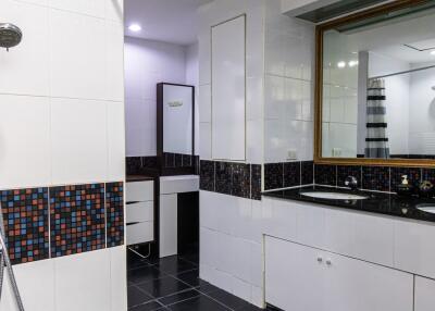 Modern bathroom with dual sinks and tiled shower