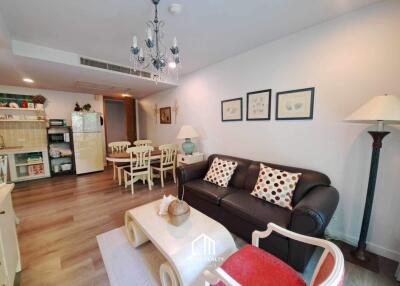 Modern living room with dining area, chandelier, and comfortable seating