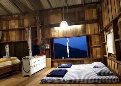 Wood-paneled bedroom with bedding and window view