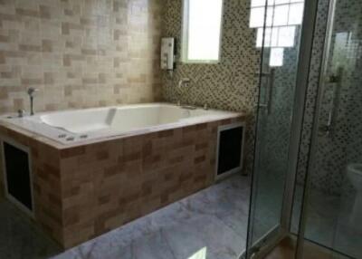 Spacious bathroom with bathtub and glass shower