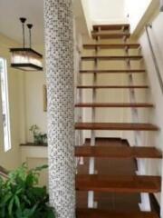 modern staircase with wooden steps and mosaic column