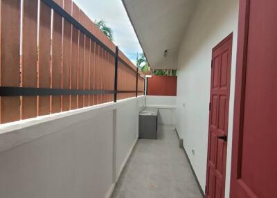 Long balcony with red door and fencing