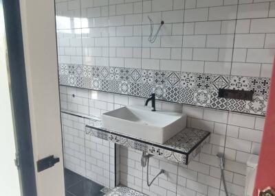 Modern bathroom with patterned tiles and wall-mounted sink