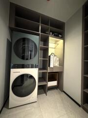 Stacked washer and dryer in a laundry room with shelves