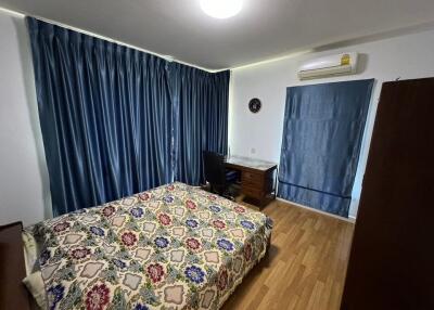 Bedroom with bed, desk, and blue curtains