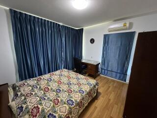 Bedroom with bed, desk, and blue curtains