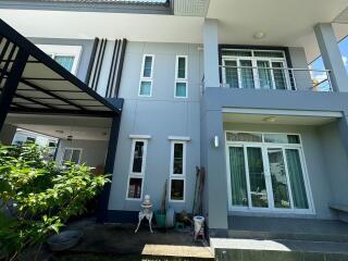 Modern two-story house exterior with large glass doors and windows