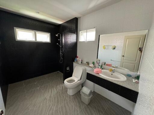 Spacious bathroom with large mirror and shower area