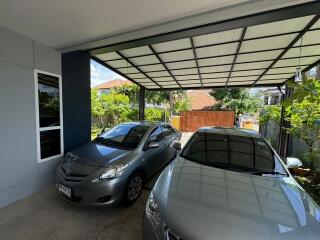 covered garage with two cars