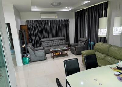 Modern living room with grey sofas, air conditioner, and dining table