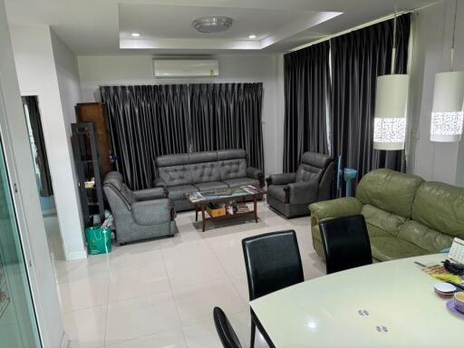 Modern living room with grey sofas, air conditioner, and dining table