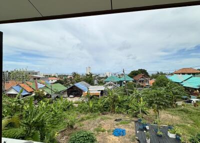 Balcony with a view of surrounding houses and greenery