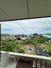 Balcony with a view of surrounding houses and greenery