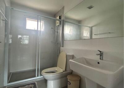 Modern bathroom with glass shower, sink, and toilet