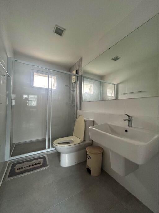 Modern bathroom with glass shower, sink, and toilet