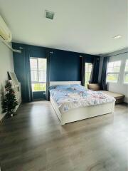 Well-lit modern bedroom with large windows