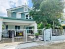 Two-story house with a white fence and garden