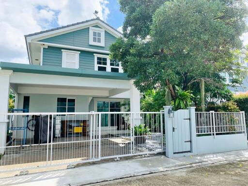 Two-story house with a white fence and garden