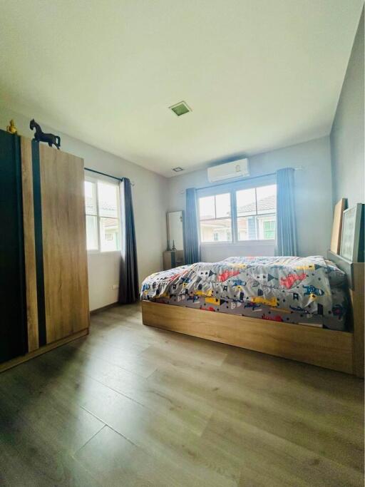 Modern bedroom with wood flooring and natural light